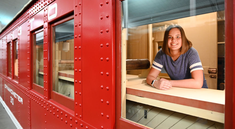 Girl smiling from a train car window - donate to the national railroad museum