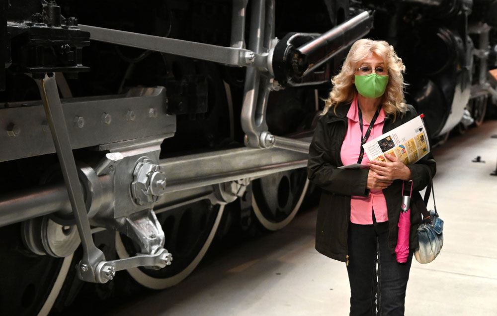 woman wearing a mask in front of a train car - health and safety protocols