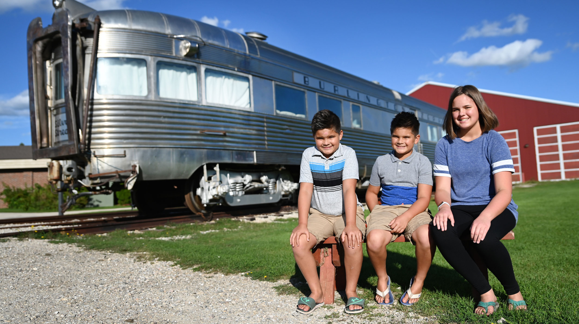 3 children in front of a train outside