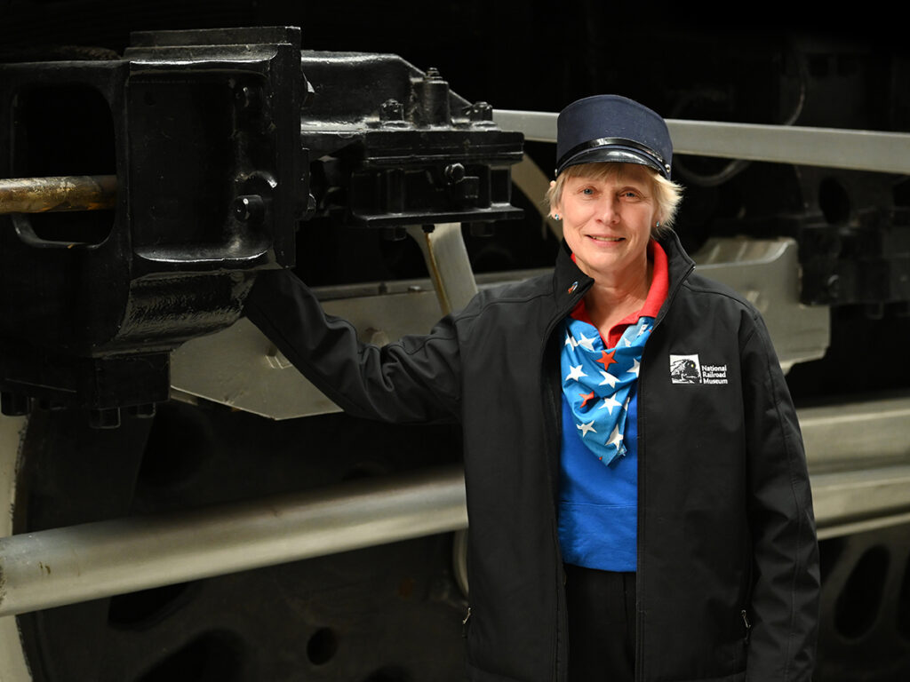 a woman standing in front of a train