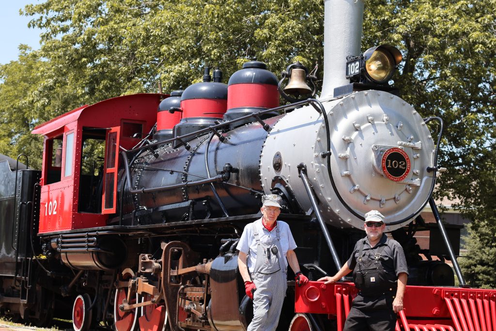 Volunteer train crew standing beside Sumter & Choctaw No. 102 at the National Railroad Museum in Green Bay, WI