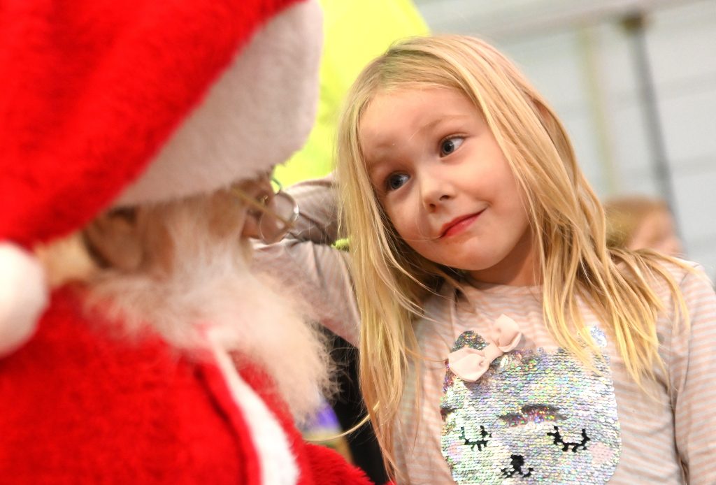 A girl sits on Santa's lap at Holidays on the Rails at the National Railroad Museum