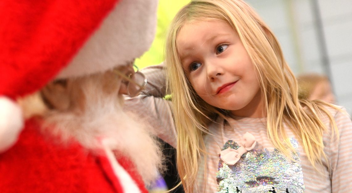 A girl sits on Santa's lap at Holidays on the Rails at the National Railroad Museum